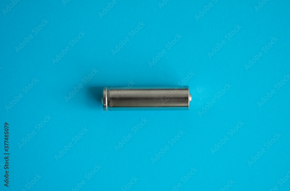 A single rechargeable battery on blue background. Silver alkaline AA battery for different device. Energy. A single rechargeable battery on blue background. Silver alkaline AA battery for different device. Energy.