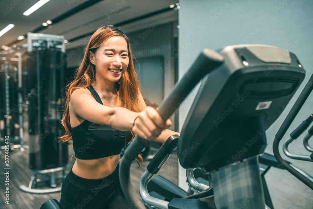 Muscular asian young woman with beautiful body doing exercises . Sporty girl lifting weights in gym. Muscular asian young woman with beautiful body doing exercises . Sporty girl lifting weights in gym.