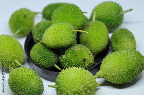Фотография Fresh green colorful spiny gourd or teasel gourd vegetables on white background