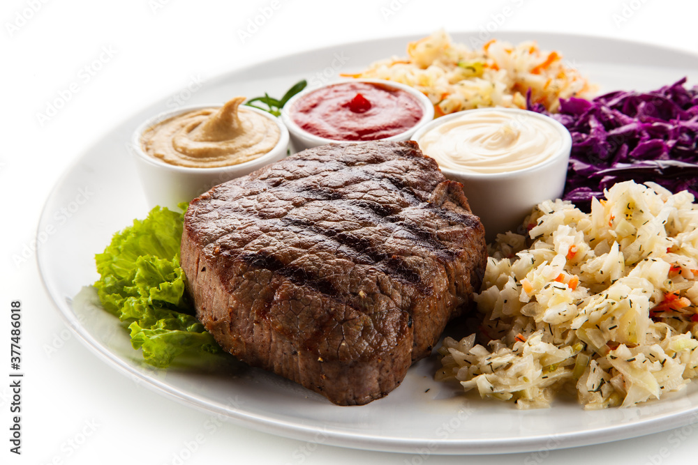 Barbecue beef steak with mix salad, mustard, mayonnaise and ketchup on white background Barbecue beef steak with mix salad, mustard, mayonnaise and ketchup on white background