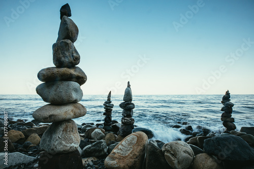 Zen style balanced stones on beach. Rock sculpture stone stacking. A stone pyramid on sea shore.