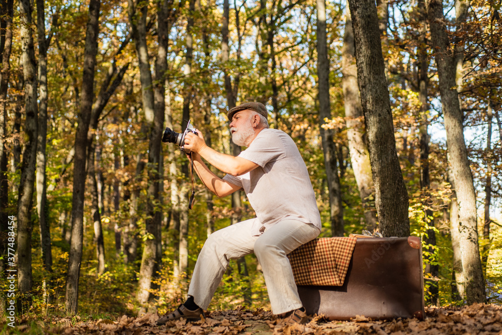 Cameraman outdoors. Landscape and nature photo shooting. Old photographer filming. Professional photographer. Pension hobby. Retro photographer. Used to manual settings. Old man shoot in nature Cameraman outdoors. Landscape and nature photo shooting. Old photographer filming. Professional photographer. Pension hobby. Retro photographer. Used to manual settings. Old man shoot in nature