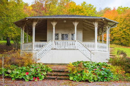 Old wooden pavilion in a parkland with autumn colours