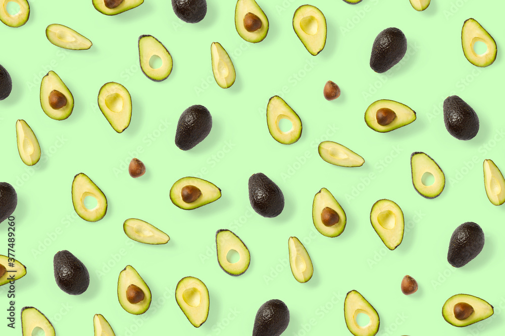 Avocado. Background made from isolated Avocado pieces on green background. Flat lay of fresh ripe avocados and avacado pieces. Avocado. Background made from isolated Avocado pieces on green background. Flat lay of fresh ripe avocados and avacado pieces.