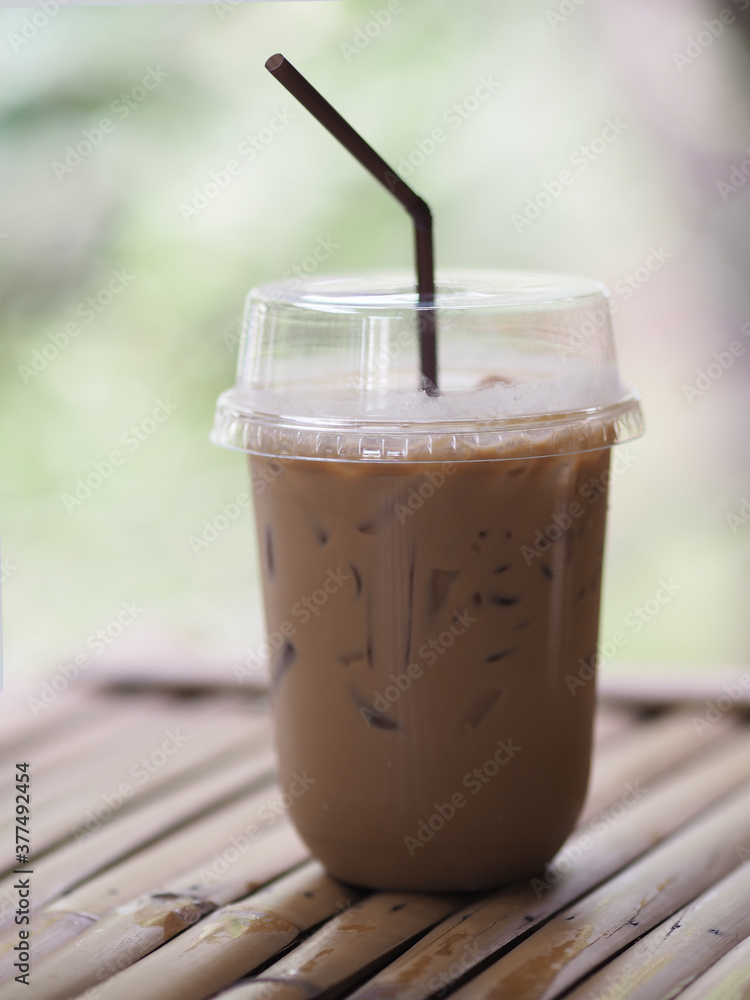 close up view of ice cubes in cold brewed coffee Cappuccino in plastic cup put on bamboo wooden desk blurred background, drink beverage close up view of ice cubes in cold brewed coffee Cappuccino in plastic cup put on bamboo wooden desk blurred background, drink beverage