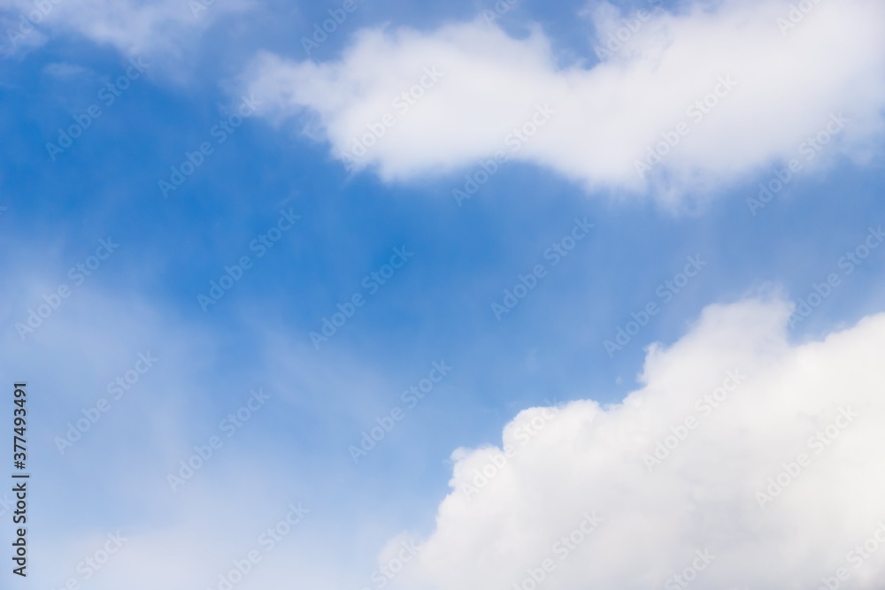 Two white fluffy clouds on a light blue sky background, copy space Two white fluffy clouds on a light blue sky background, copy space