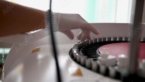 A nurse sorts blood tests in a centrifuge for examination