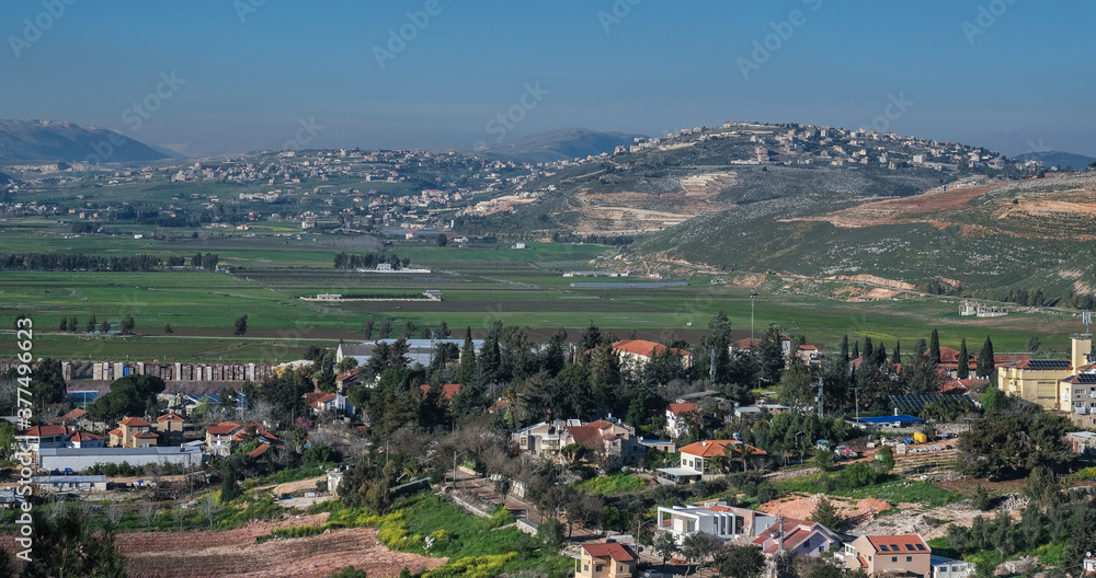 View of the town of Metula, situated on the Israeli-Lebanese border, at the foot of Mount Hermon (in the background), as seen from Dado lookout point, Upper Galilee, Israel.
