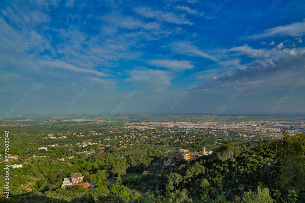 Vista de sierra y ciudad de Córdoba con vegetación diversa con extensiones de estepa y nubes en el cielo