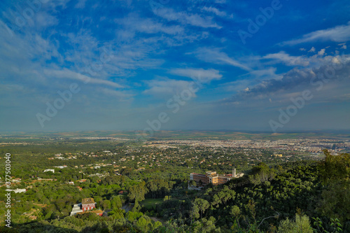 Vista de sierra y ciudad de Córdoba con vegetación diversa con extensiones de estepa y nubes en el cielo