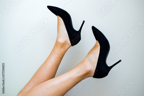 Perfect part of beautiful woman feet in black high hell sandals against white background