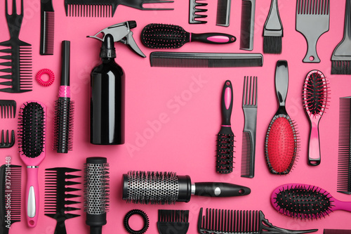 Frame of modern hair combs and brushes on pink background, flat lay. Space for text