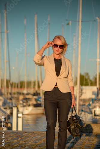 Business woman posing in harbor near yachts