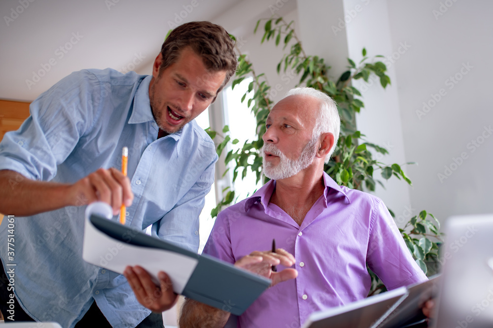Fototapeta premium Two businessmen working on laptop.