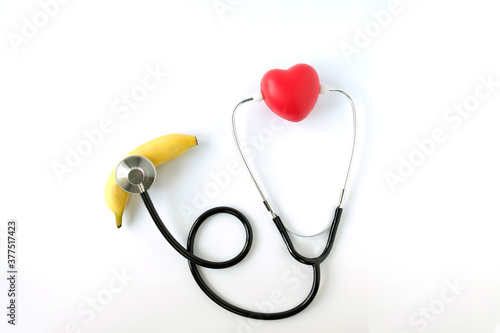 Heart shaped squeeze ball,stethoscope and banana isolated on white background.Erectile dysfunction a warning sign of heart disease concept.