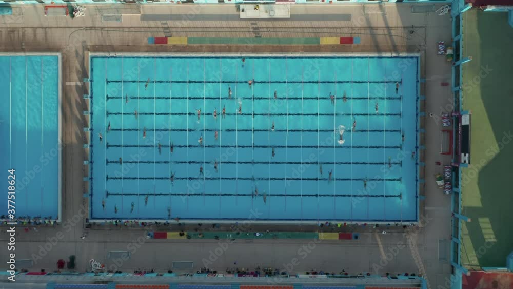 Swimmers training doing Laps in Blue Pool, Epic Birds Eye Perspective in Sunshine Swimmers training doing Laps in Blue Pool, Epic Birds Eye Perspective in Sunshine