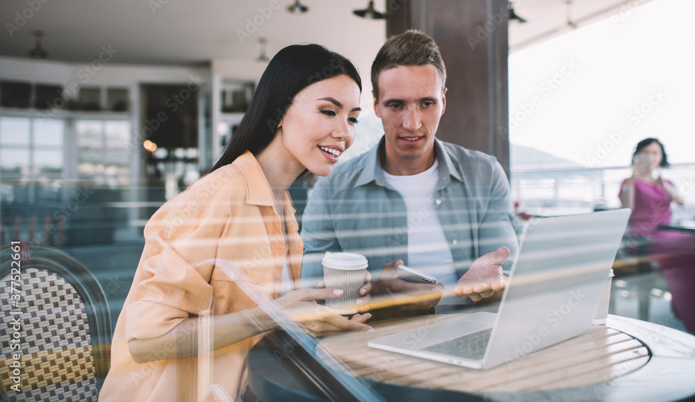 Couple surfing laptop in cafe having discussion Couple surfing laptop in cafe having discussion