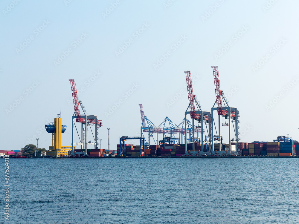 Large cranes for loading goods on large marine cargo ships at the container terminal in the port of Odessa sea port on a foggy day