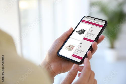 Bild auf Leinwand Woman shopping online via smartphone indoors, closeup