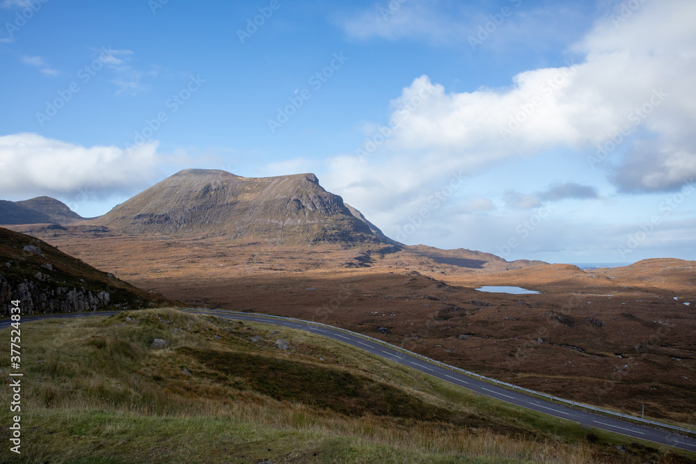 Scottish road passing lake and mountains