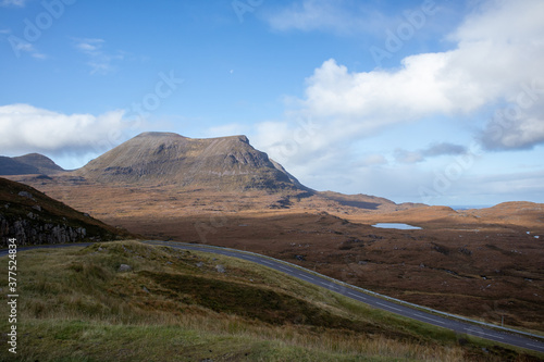 Scottish road passing lake and mountains