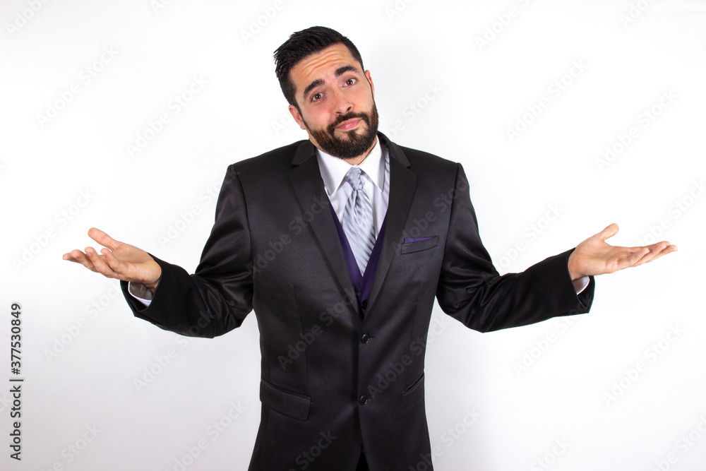 Handsome businessman in suit shrugging shoulders. No idea, don't know concept. Attractive young stylish bearded man doubting and confused. Medium shot. White background. Handsome businessman in suit shrugging shoulders. No idea, don't know concept. Attractive young stylish bearded man doubting and confused. Medium shot. White background.