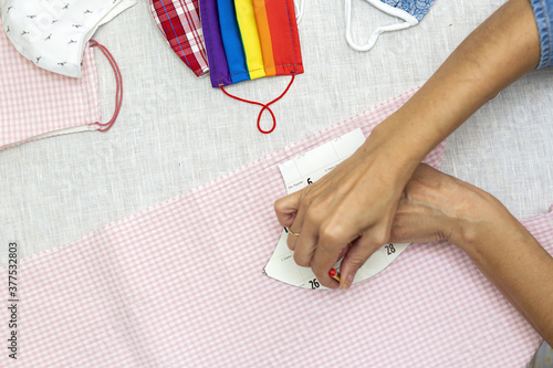 Woman's hands cutting face masks on for protection