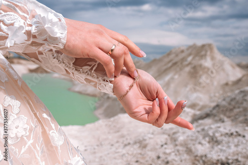 Hands of the bride on the background of blue quarries