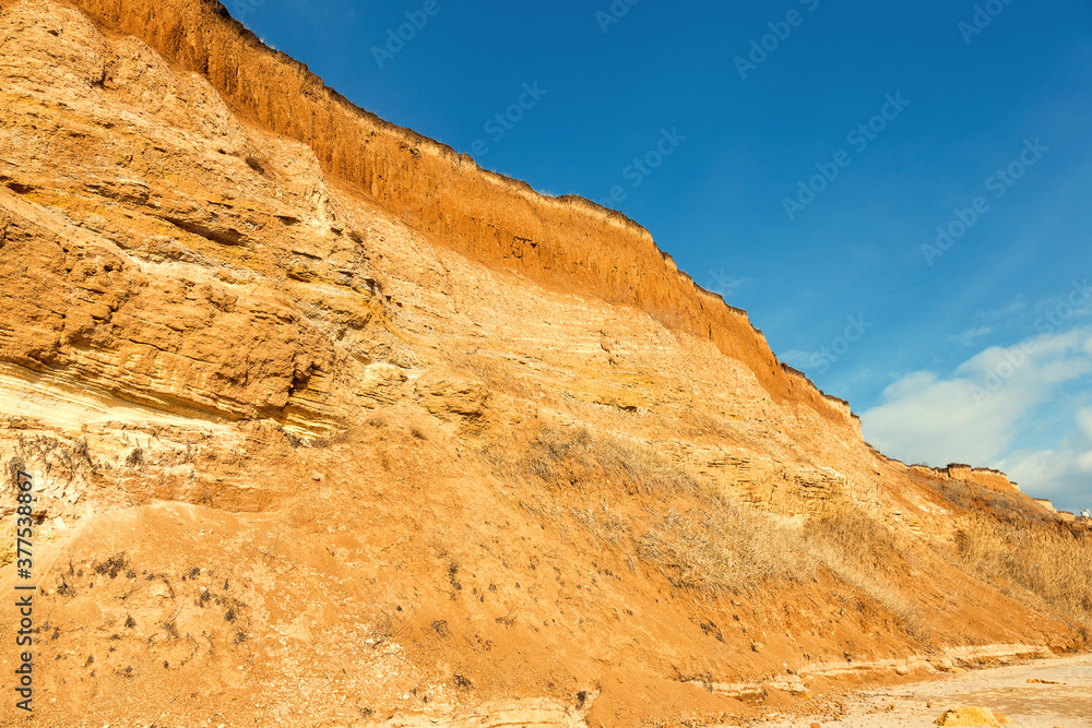 Fototapeta premium Rockslide. Mountain landslide in an environmentally hazardous area. Large cracks in earth, descent of large layers of earth blocking road. Mortal danger of dam at foot of landslide slopes of mountain