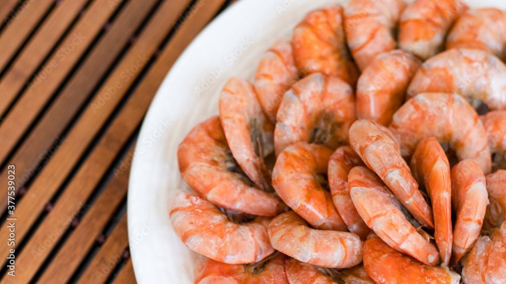 Tiger prawns on a large white plate, blurred background. Seafood. Tiger prawns on a large white plate, blurred background. Seafood.