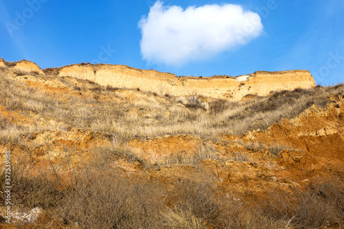 Rockslide. Mountain landslide in an environmentally hazardous area. Large cracks in earth, descent of large layers of earth blocking road. Mortal danger of dam at foot of landslide slopes of mountain