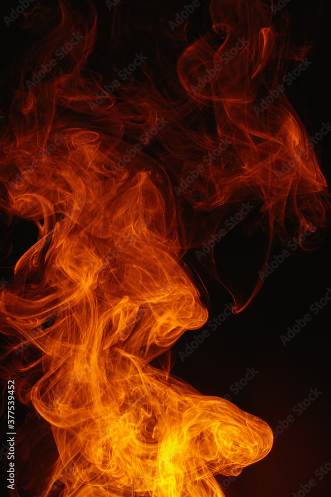Orange smoke on a dark background. Intricate swirls of colored smoke. An abstract imitation of night flames. Orange smoke on a dark background. Intricate swirls of colored smoke. An abstract imitation of night flames.