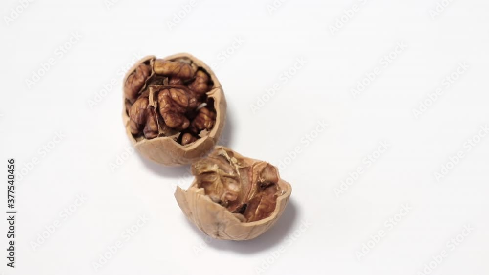 cracked on two half walnut rotating on white background close-up
cracked on two half walnut rotating on white background close-up