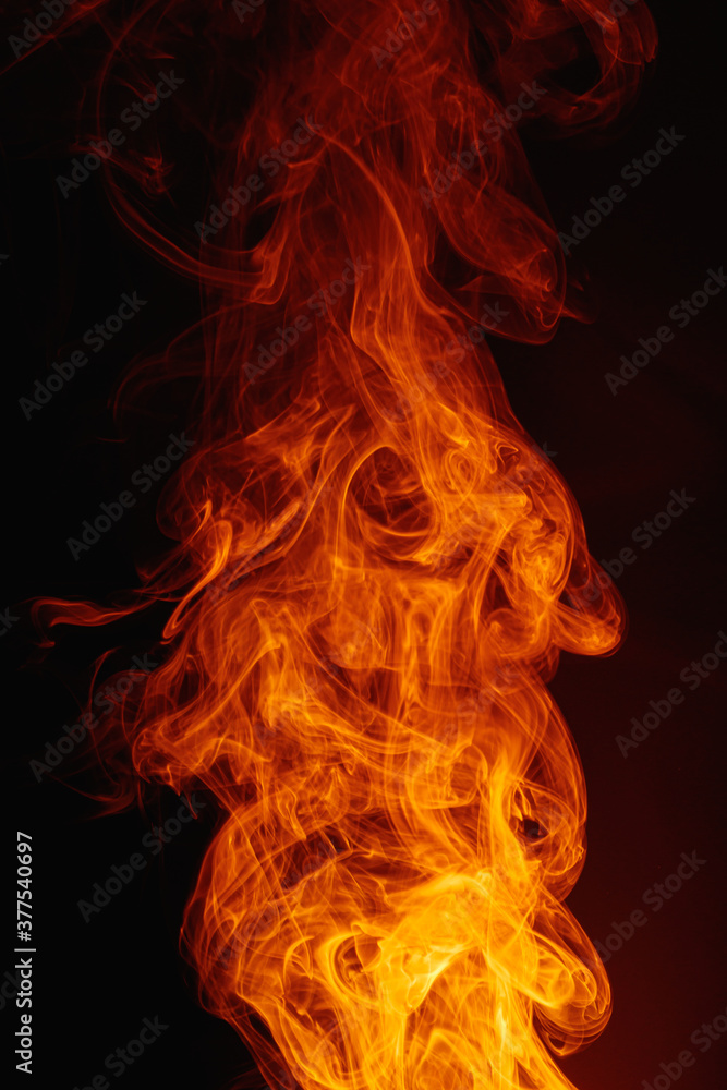 Orange smoke on a dark background. Intricate swirls of colored smoke. An abstract imitation of night flames. Orange smoke on a dark background. Intricate swirls of colored smoke. An abstract imitation of night flames.