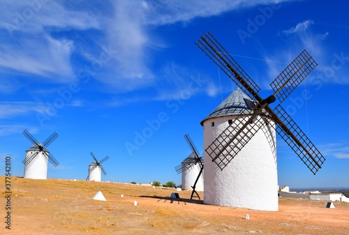 Four windmills in sunny day and dark blue sky. Campo de Criptana.