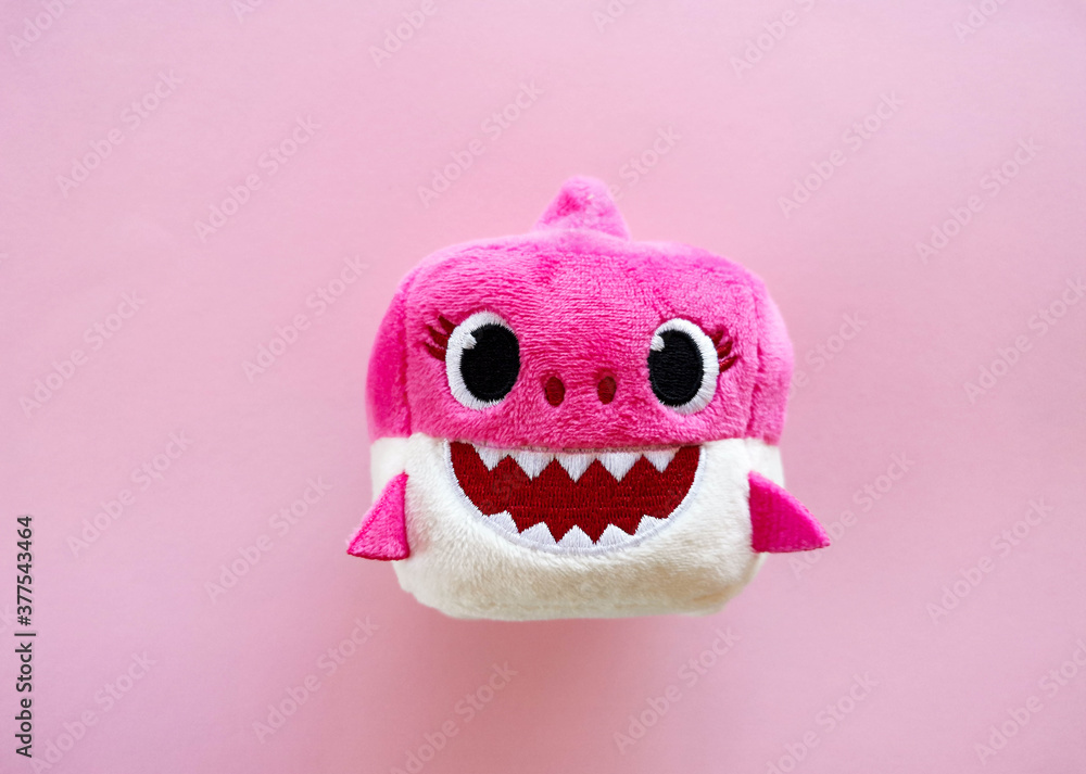 Adorable pink baby shark soft toy on pink background. Sweet childhood