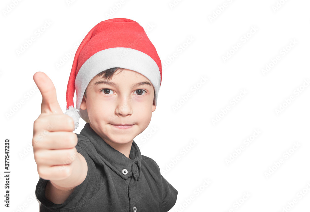 schoolboy kid in Santa hat on the emotion of joy thumbs up schoolboy kid in Santa hat on the emotion of joy thumbs up