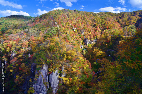 絶景の錦秋鳴子峡のカラフルな紅葉と陸羽東線のトンネル・陸橋（横位置）