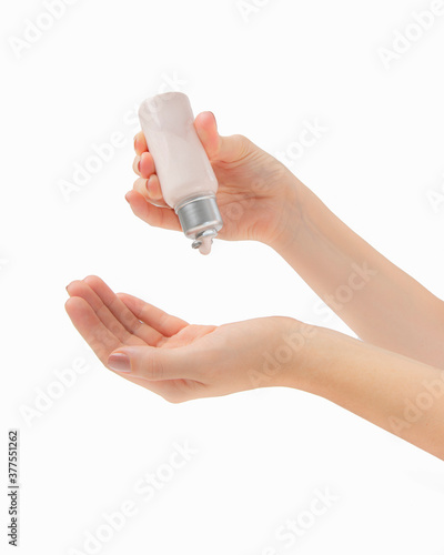 hand holding a bottle of cream, serum or treatment. After manicure 