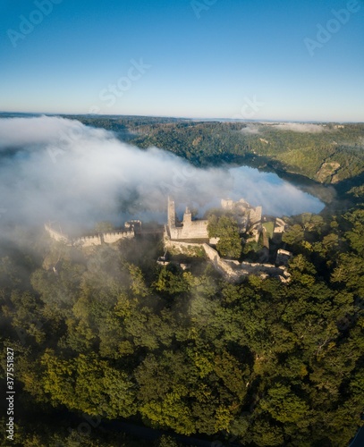 Cornstein Medieval castle in South Moravia region during amazing sunrise, Czech republic, Europe. Aerial drone view. Summer or autumn time. Misty and sunny atmosphere. © Michal