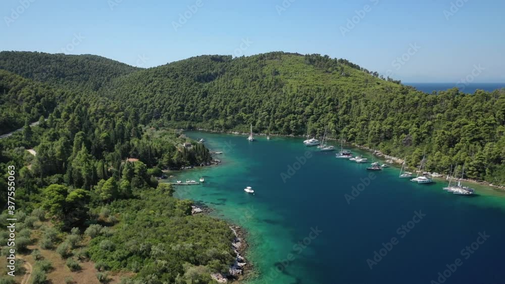 Aerial drone video of safe small fjord harbour near bay of Panormos a popular yacht and sail boat anchorage with calm sea covered with pine trees, Skopelos island, Sporades, Greece Aerial drone video of safe small fjord harbour near bay of Panormos a popular yacht and sail boat anchorage with calm sea covered with pine trees, Skopelos island, Sporades, Greece