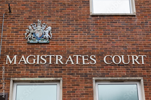 the sign on the exterior or facade of a magistrates court with the royal crest above it