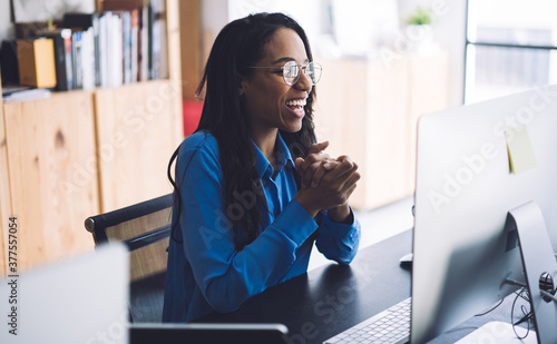 Joyful African American businesswoman using computer at office