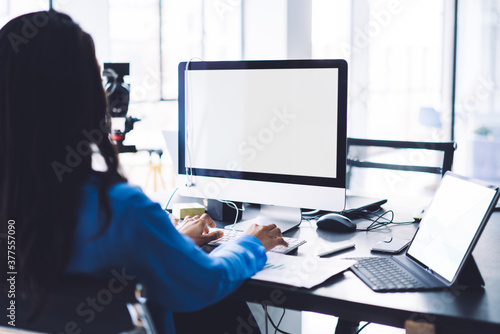 Female office employee working on computer with white screen