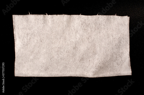 Disposable synthetic non- woven cleaning cloths in a roll, on a black background. photo