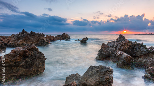 Puesta de sol en la costa de Menorca con mar azul 