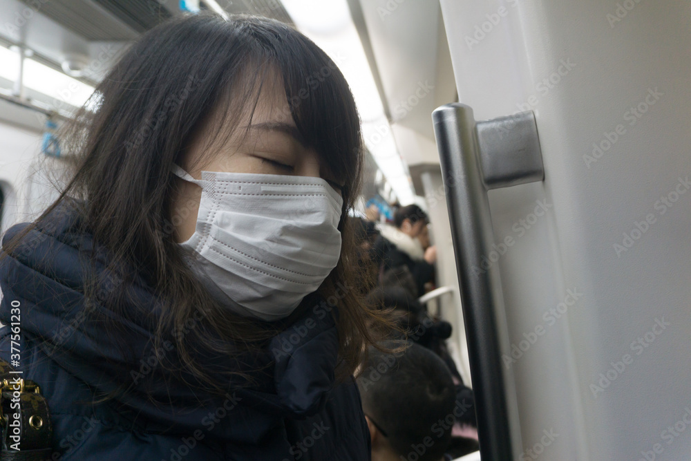 マスク着用の女性 地下鉄 マスク着用の女性 地下鉄