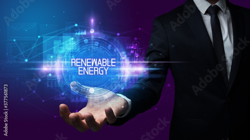 Man hand holding RENEWABLE ENERGY inscription, technology concept