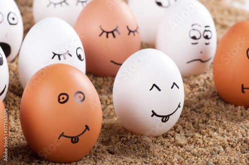 group of Funny crazy smiling eggs on a sand