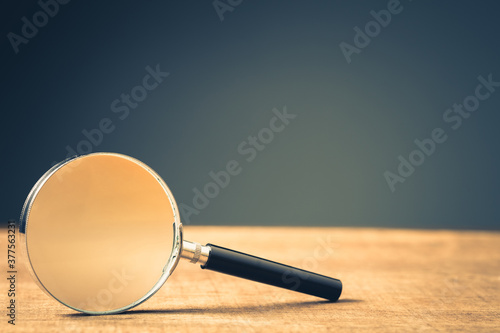 Magnifying Glass on Wood Background